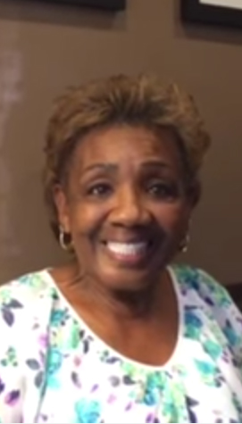 Elderly woman with short hair smiling at the camera.