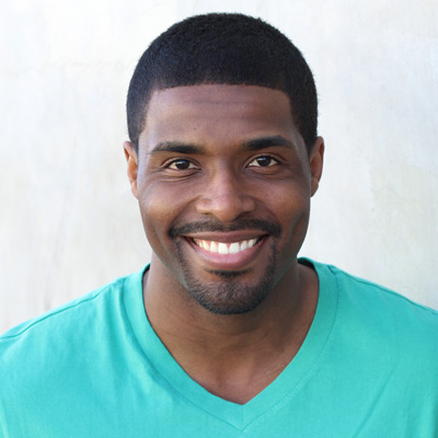 An elderly couple sharing a joyful moment together, with both smiling broadly at the camera.